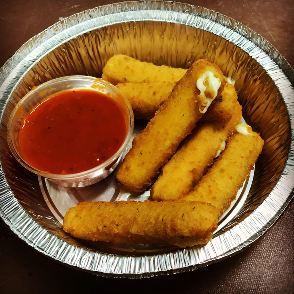 Golden-brown mozzarella sticks with melted cheese and a side of red marinara sauce in a foil container.