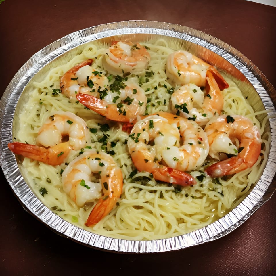 Shrimp scampi with pasta and parsley in a round aluminum takeout container from Nick's Pizza.